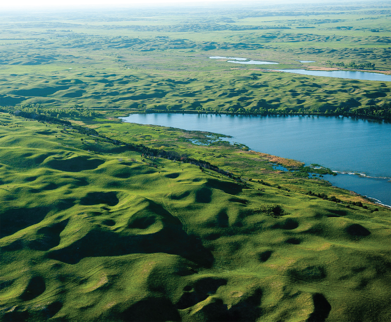 Aerial photo looking northwest at Hackberry Lake, Valentine National Wildlife Refuge, Cherry County. The lake is surrounded by 90- to 165-foot-high barchan and barchanoid ridge dunes with abundant healed blowouts.