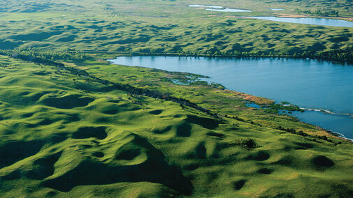 Aerial photo looking northwest at Hackberry Lake, Valentine National Wildlife Refuge, Cherry County. The lake is surrounded by 90- to 165-foot-high barchan and barchanoid ridge dunes with abundant healed blowouts.